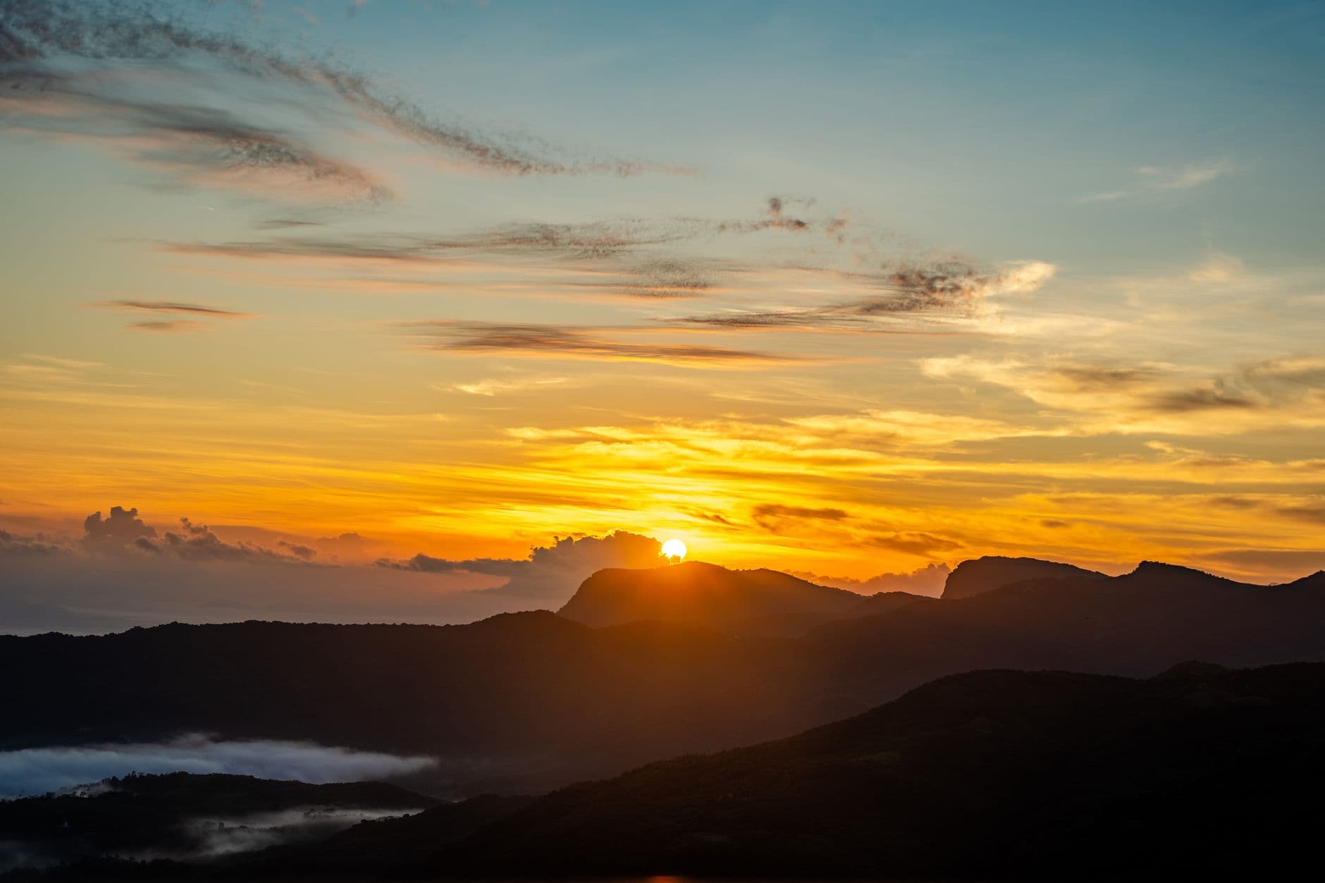 First light breaking over the hills from the summit