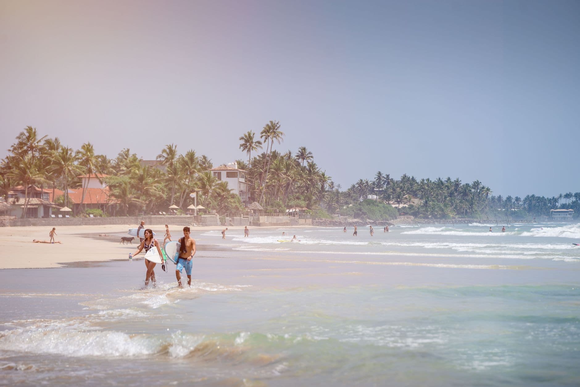 Surfer heading out at a Sri Lankan point break
